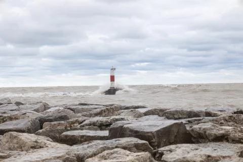 Waves crashing over lighthouse wall on lake Michigan in Kenosha Stock Photos
