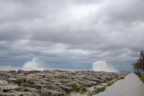 Waves crashing over lighthouse wall on lake Michigan in Kenosha Stock Photos