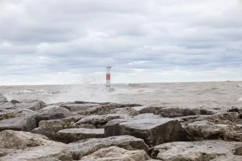 Waves crashing over lighthouse wall on lake Michigan in Kenosha Stock Photos
