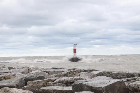 Waves crashing over lighthouse wall on lake Michigan in Kenosha Stock Photos