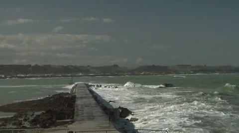 Waves crashing over outlet pipe Stock Footage 8509716