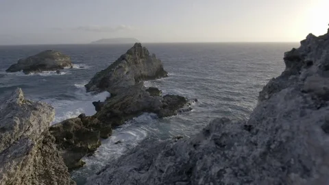 Waves crashing over rock formations in slow motion at sunset Stock Footage 74906964
