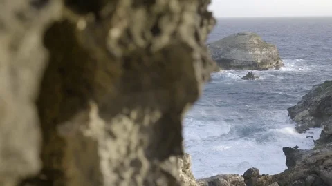 Waves crashing over rock formations at sunset Stock Footage 74907247