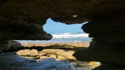 Waves crashing over rocks in a beach cave Stock Footage 210896170