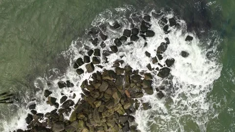 Waves crashing over rocks - drone top-down view. Stock Footage 323782592