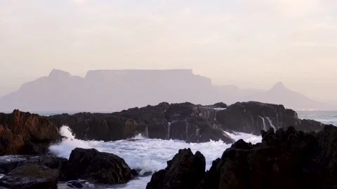 Waves crashing over rocks in front of Table Mountain Stock Footage 234630806