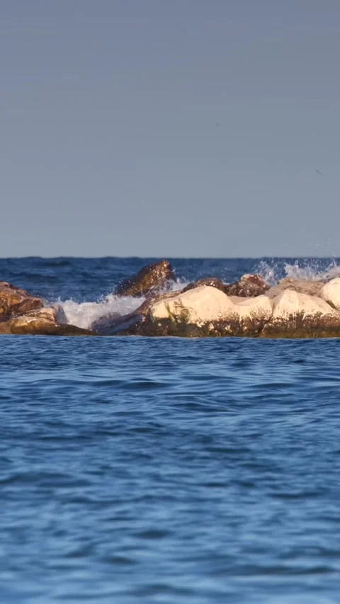 Waves crashing over rocks in ocean setting 스톡 동영상 345226702
