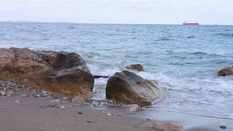 Waves crashing over rocks at a serene beach during early morning light Stock Footage 285085009
