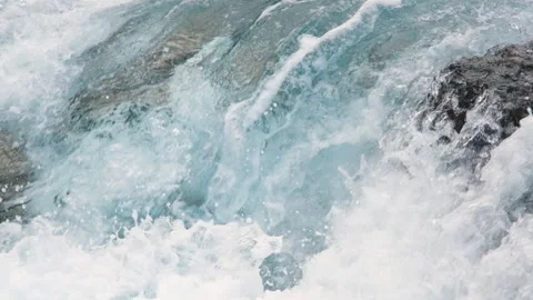 Waves crashing over rugged black volcanic rocks, creating white foam, splashes Stock Footage 345960684