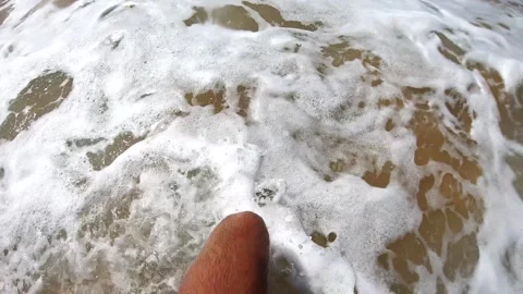 Waves crashing over sandy beach, showcasing the dynamic motion of water as it Видео 334665807