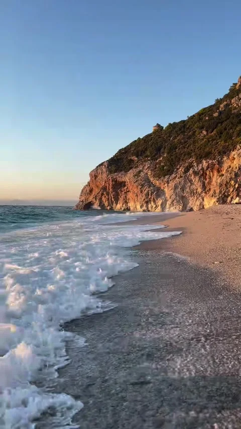 Waves Crashing on Pebble Beach and Cliffs Video stock 341317025