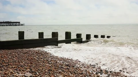 Waves crashing onto a pebble beach Stock Footage 211823825