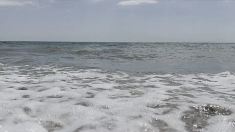 Waves Crashing Onto A Pebble Beach Stock Footage 240480611