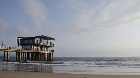 Waves crashing at pier on Durban beachfront with boat Stock Footage 80592238