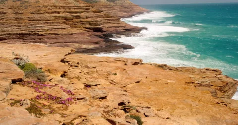 Waves crashing onto red cliffs, Kalabarri National Park, Western Australia 動画素材 60699596