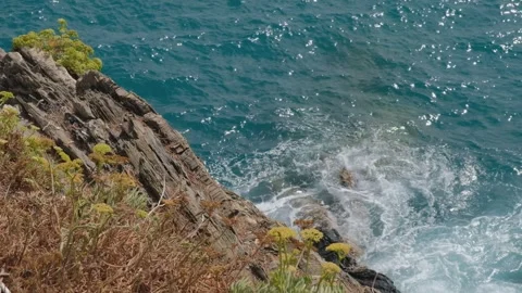 Waves crashing on a rock cliff Stock Footage 258057959