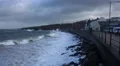 Waves crashing on rocks and coastal UK town early morning after hurricane HD Footage