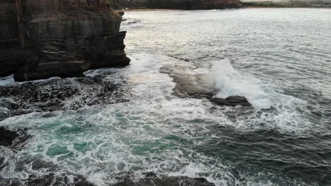 Waves crashing on rocks and a massive beautiful beach Stock Footage 136547974
