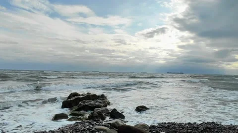 Waves crashing on rocks in the beach with cloudy sky 库存影片 219609419