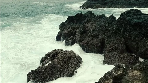 Waves crashing the rocks on the beach Stock Footage 292263740