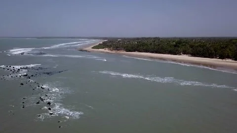 Waves crashing on rocks with beach, trees and buildings in background Stock-Footage 221577310