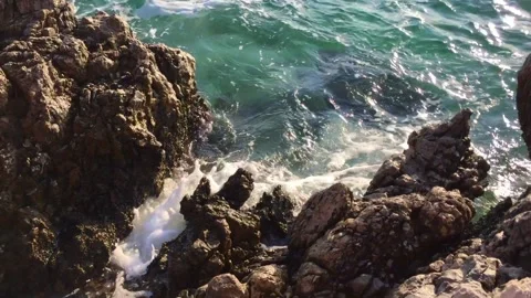 Waves crashing on rocks. Blue water beautiful natural rocky sea shore in sunny d Stock Footage 147584511