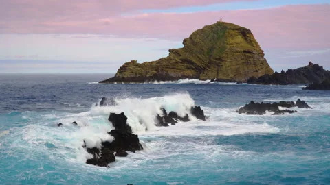 Waves crashing on rocks, cliff with lighthouse in the background Stock Footage 146632229