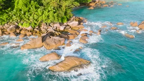 Waves crashing on rocks at the edge of a lush tropical forest. Seychelles Stock Footage 304744624