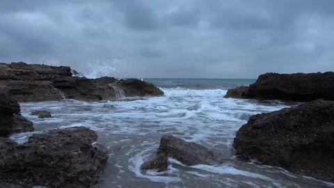 Waves crashing on the rocks of the sea on a cloudy day Stock Footage 88596457