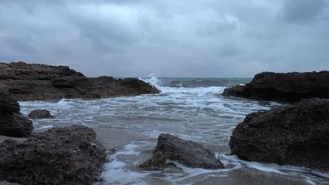 Waves crashing on the rocks of the sea on a cloudy day Stock Footage 88703517