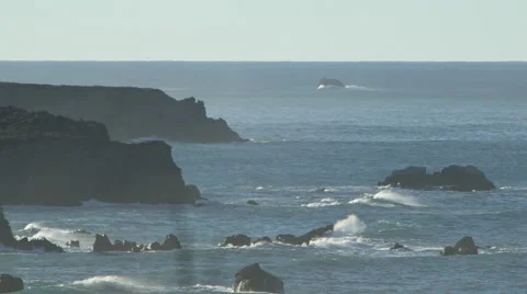 WAVES CRASHING ON ROCKS WITH SPRAY BLOWING OFF AND BLUFFS Stock Footage 59071308