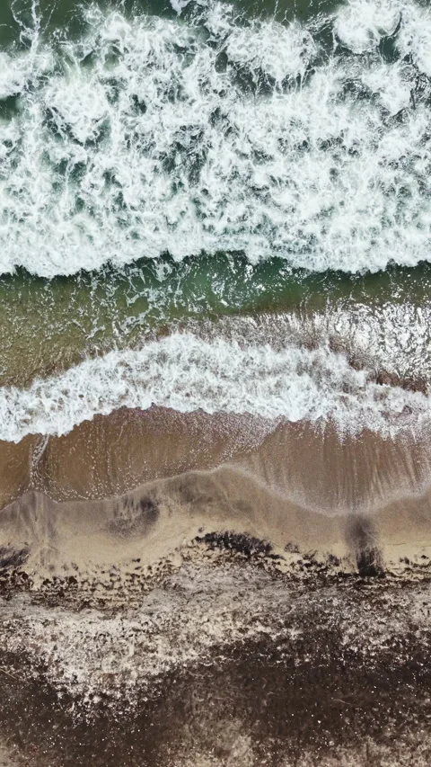 Waves crashing on sandy beach during daytime with clear water and shoreline Stock Footage 337948916