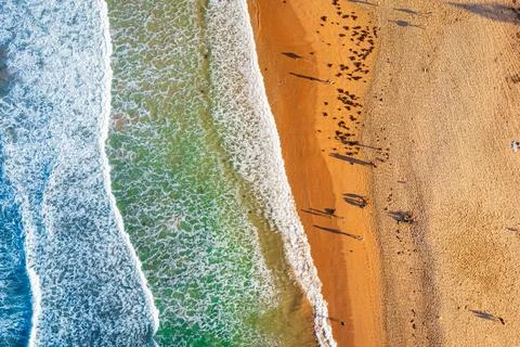 Waves crashing on the sandy beach Stock Photos