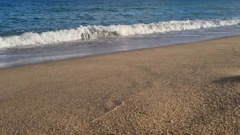 Waves crashing on sandy shore under clear blue sky Stock Footage 321199140