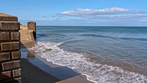 Waves crashing in to the sea wall Video stock 313565633