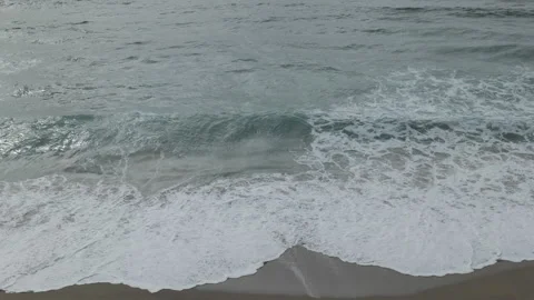 Waves crashing onto the shore, creating white foamy patterns. Stock Footage 296779724