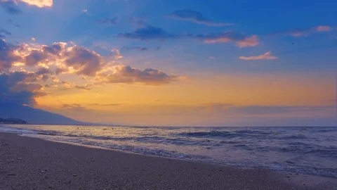 Waves crashing on the shore with dramatic sky and sunbeams shining Stock Footage 100218092