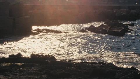 Waves crashing on the shore at sunset, backlit, HD Stock Footage 147459857