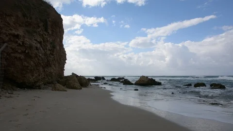 Waves crashing on shoreline with moody dramatic sky  動画素材 100091918