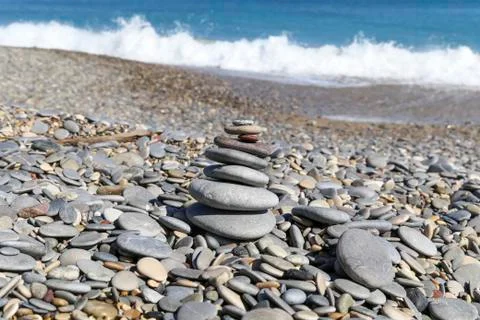 Waves crashing on shoreline with pebble stack in the foreground Stock Photos