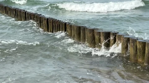 Waves crashing in slow-motion against wooden groins in the Baltic Sea at Gr.. Stock Footage 310194034