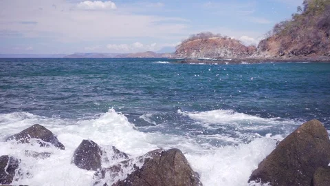 Waves crashing in slow motion onto rocks on the shoreline Stock Footage 103218818