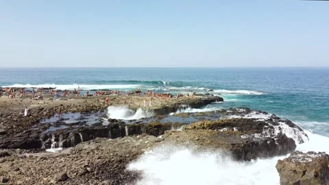 Waves crashing strongly against the rocks of the coast with some people Stock Footage 279217469