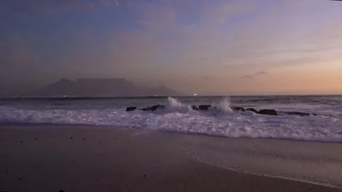 Waves crashing at sunset with Table Mountain in the background Stock Footage 315761497