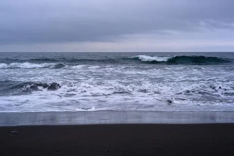 Waves crashing on a tranquil beach during a cloudy day in Russia Stock Photos