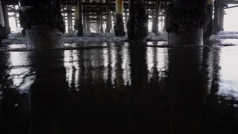 Waves Crashing In Under Old Weathered Pier   Stock Footage 96043594