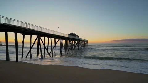 Waves Crashing under the Pier during Sunrise Stock Footage 241029359