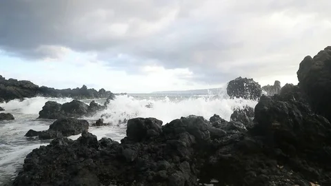 Waves crashing onto volcanic rock Stock Footage 79126247