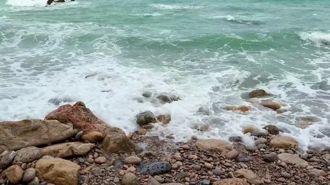Waves create a beautiful spectacle as they crash upon the rugged rocky shor.. Stock Photos