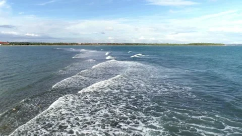 Waves create patterns on the ocean surface near a tropical island Stock Footage 312679726
